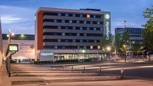 Un hôtel moderne, reconnaissable à son enseigne « Campanile » bien visible, avec de nombreux étages et un hall d’entrée bien éclairé.