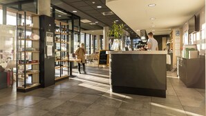 Un intérieur moderne comprenant un comptoir d’accueil, des vitrines et un espace salon.