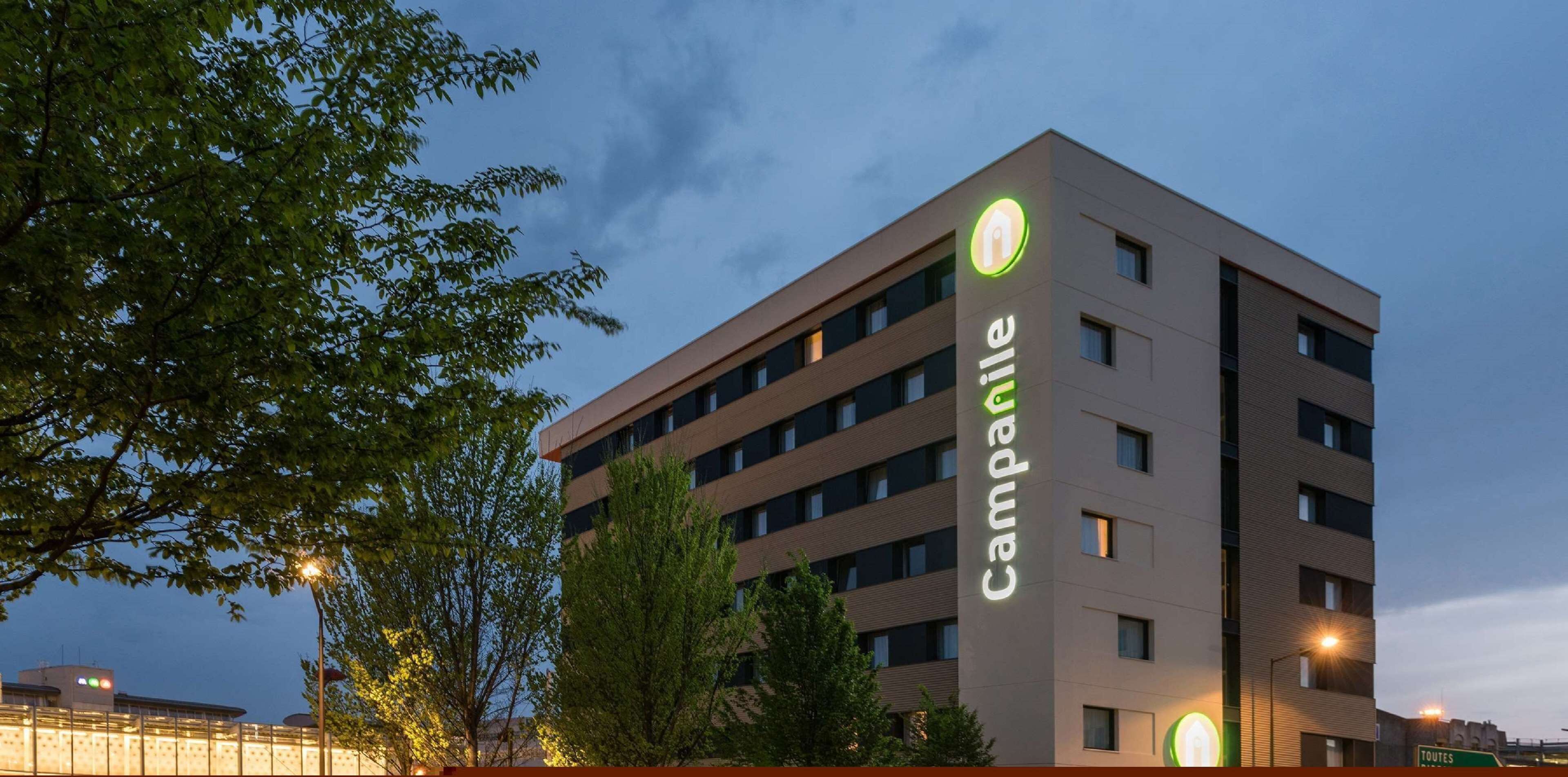 A multi-story hotel with a modern design, featuring a prominent 'Campagnie' sign on the facade.