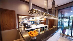 A modern hotel lobby with a curved reception desk, a bowl of oranges, and a glass display case.