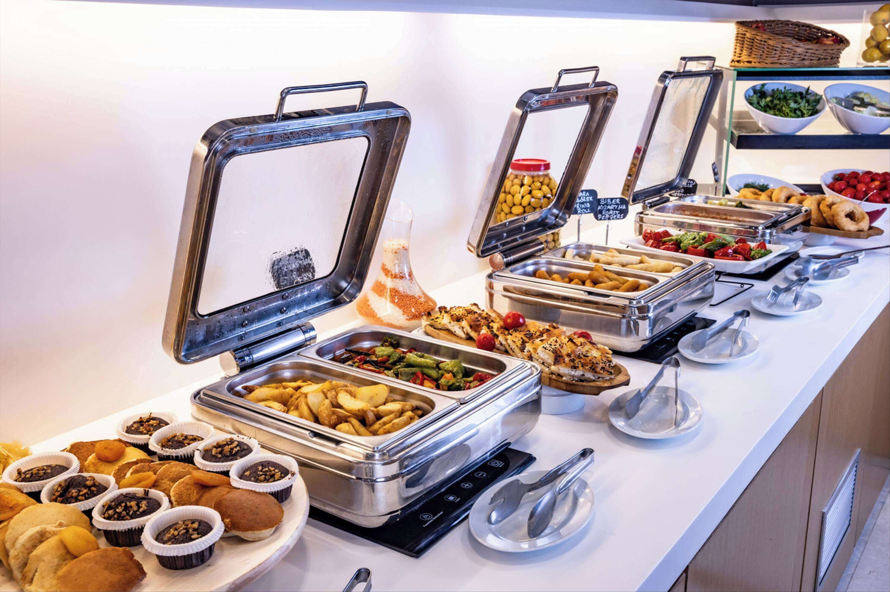 A buffet with various food items and utensils.