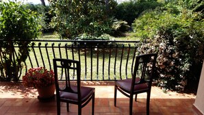 A patio with two wooden chairs and a potted plant. - Villa Anna (Osimo)