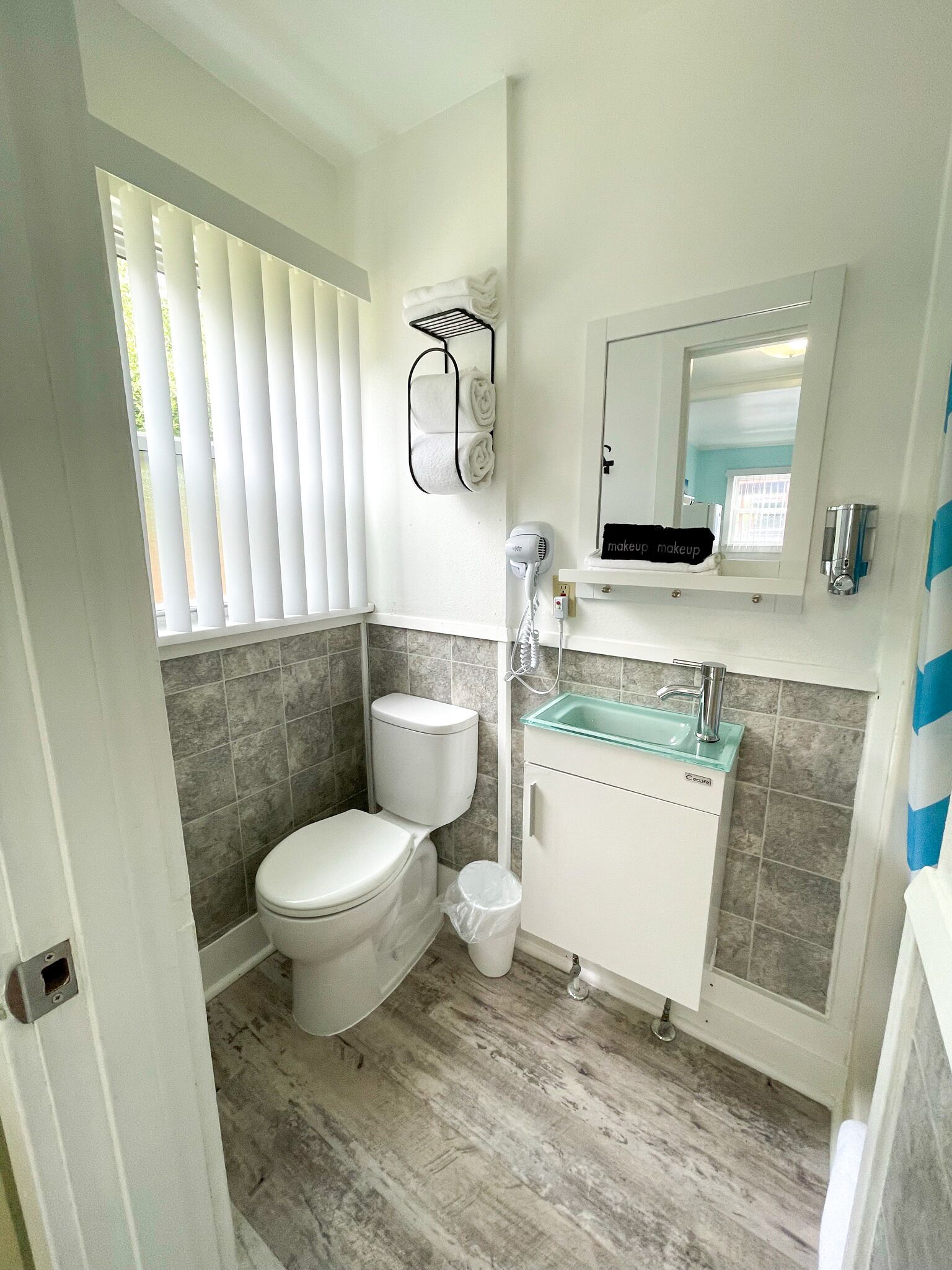A bathroom with a toilet, a sink, and a mirror.