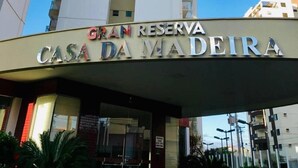 Un hôtel appelé GRAN RESERVA CASA DA MADEIRA, avec une façade moderne et un ciel bleu clair en arrière-plan.