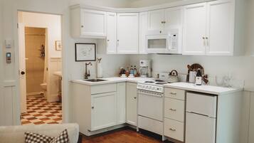 A kitchen with white cabinetry, a microwave, a stove, and a dishwasher.
