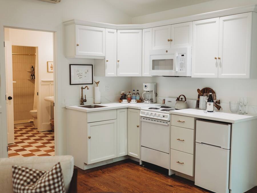 A kitchen with white cabinetry, a microwave, a stove, and a dishwasher.