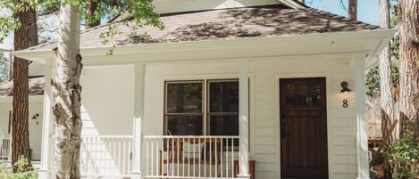 A white single-story house with a porch, a front door, and a mailbox.
