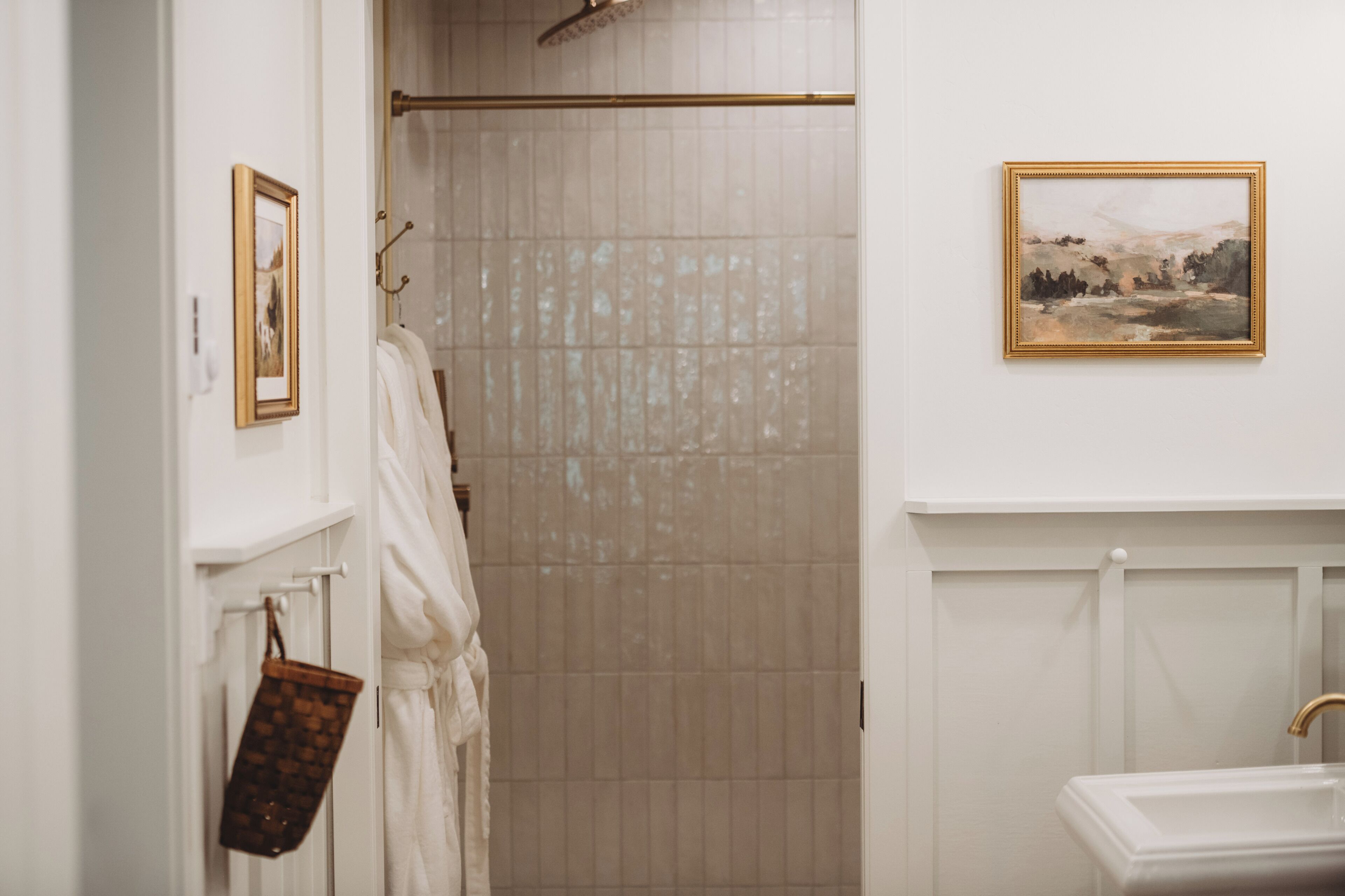 Un baño con ducha, lavamanos y un cuadro en la pared.