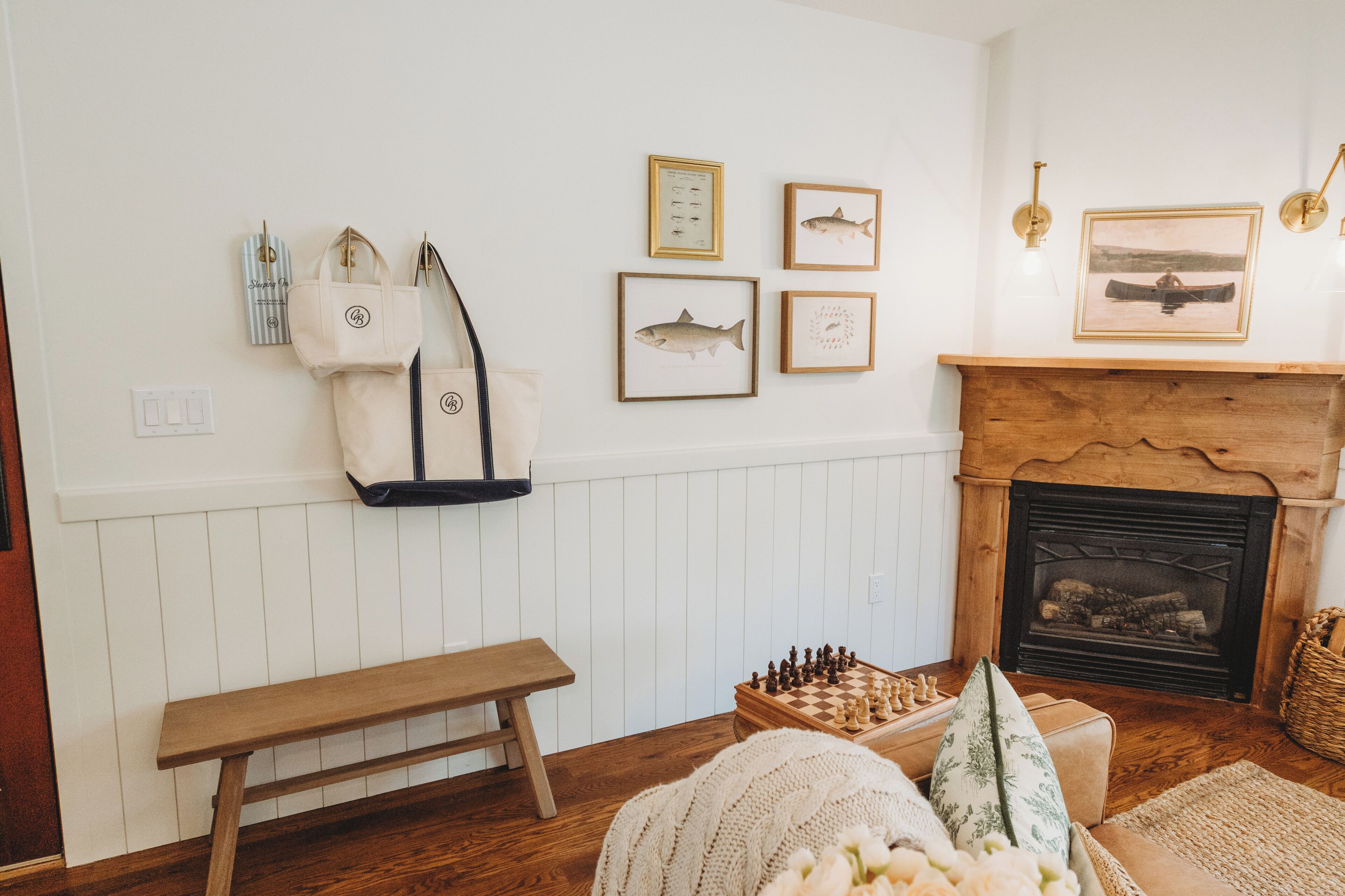 A cozy living room with a wooden bench, a fireplace, and wall-mounted bags.
