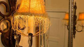 Un candelabro con luz cálida, un adorno de pared y un espejo.