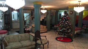 Eine geräumige Lobby mit Weihnachtsbaum, einer Couch und einer Treppe.