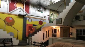 Eine Hotteallée mit Treppe, einer Couch, einem Wasserspender und einem Feuerlöscher.