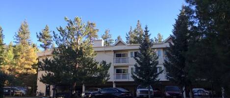 A multi-story building with a parking lot in front.