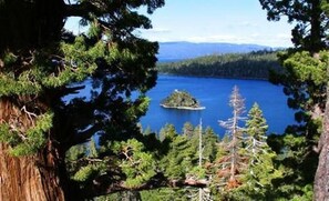 A lake surrounded by dense forest and mountains in the background. - The Lodge at Kingsbury Crossing (Stateline)