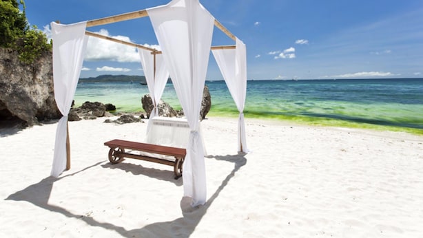 A beach setting with a white canopy structure and a bench. - Naqalia Lodge (Wayasewa Island)
