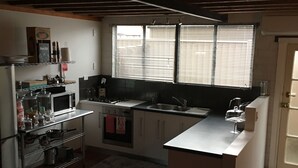 A compact kitchen with a microwave, stove, sink, and a small island.