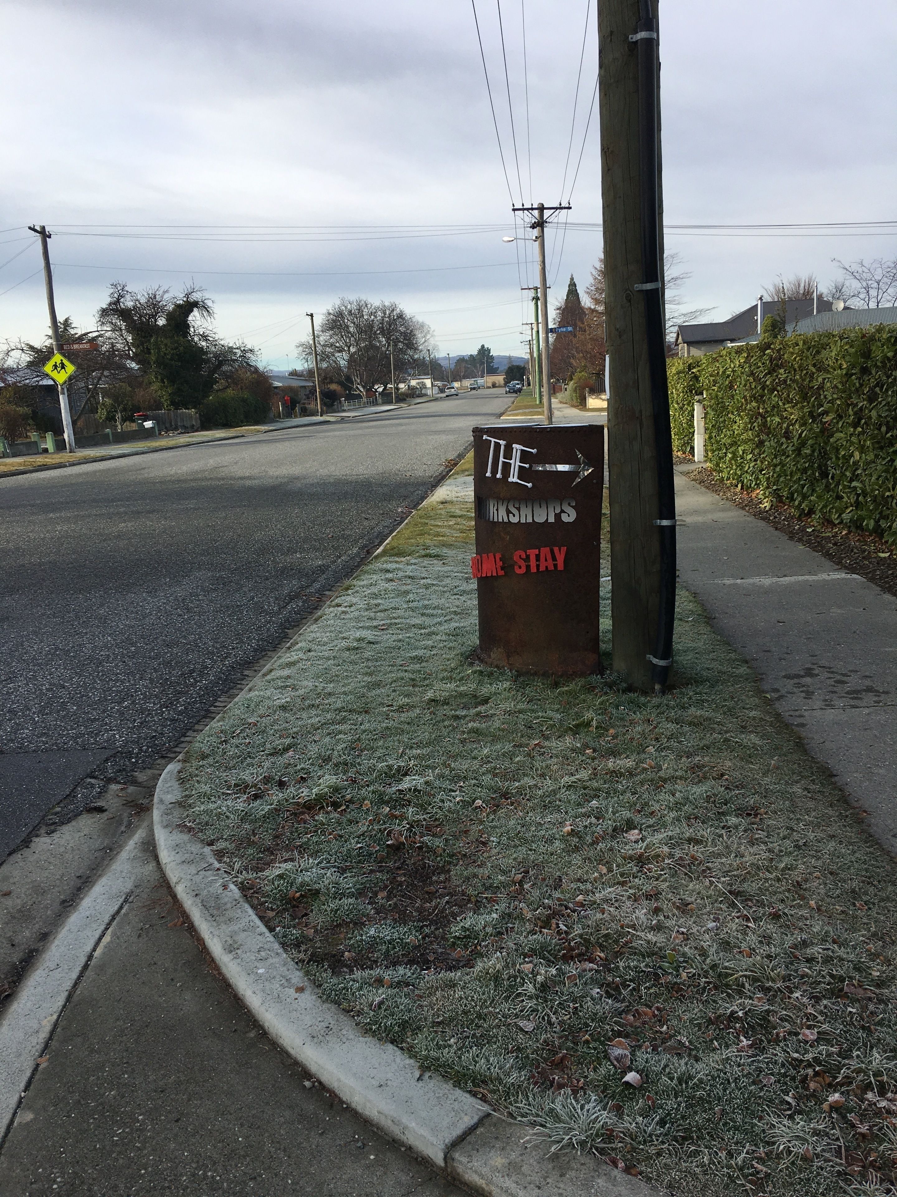 A street with a signboard advertising "The Workshops Home Stay".