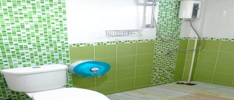 A bathroom with a toilet, a shower, and a green-tiled wall.