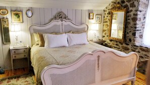 Une chambre à coucher comprenant un lit, des tables de chevet, une commode, un miroir et des tableaux encadrés accrochés au mur.