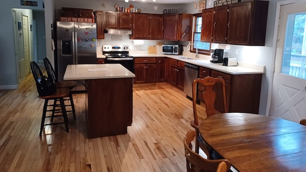 Una cocina moderna con armarios de madera, electrodomésticos de acero inoxidable y una isla central.