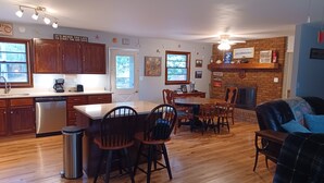 Una cocina amplia con armarios de madera, lavavajillas y un comedor con mesa y sillas.
