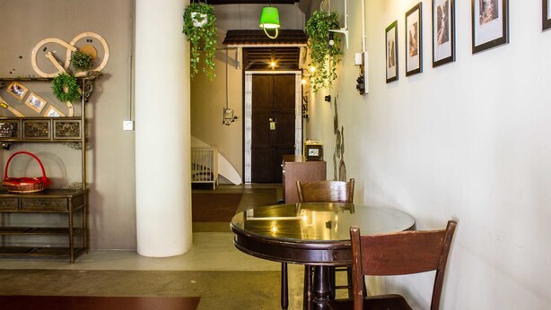 A dining area with a round table, chairs, and hanging plants. There is a staircase leading to another room. - Homeaway Townhouse 1934 (George Town)