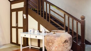 A staircase with wooden railings and a white table with a vase and some items on it. - Homeaway Townhouse 1934 (George Town)