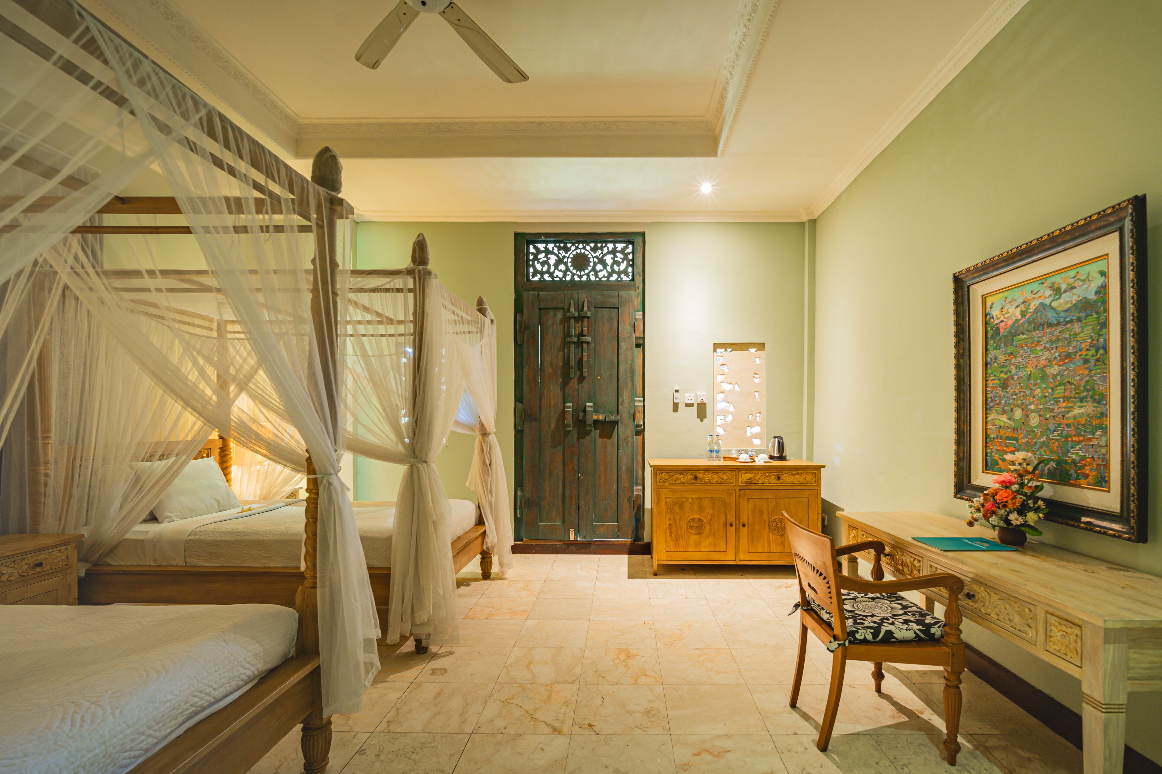 Une chambre à coucher avec un lit à baldaquin, un bureau en bois et une chaise.