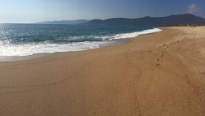 A beach with a clear sky, calm sea, and distant mountains. - Awesome residence with a pool and a great view (Propriano)