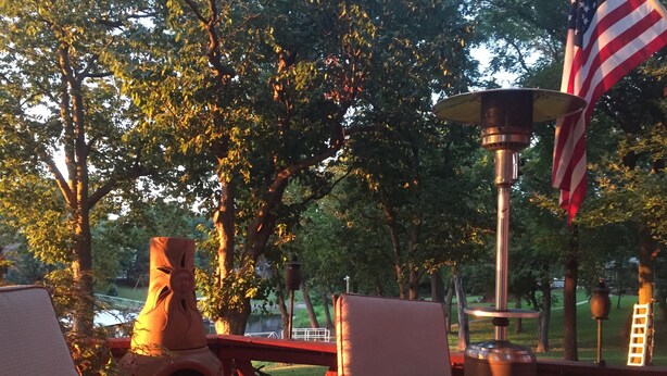 Ein Sitzbereich im Freien mit Tisch, Stühlen, einer Zierurne und einer amerikanischen Flagge.