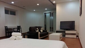 A hotel room with a large bed, a sofa, a TV, and a desk. - WTE Binjai 8 Suites (Kuala Lumpur)
