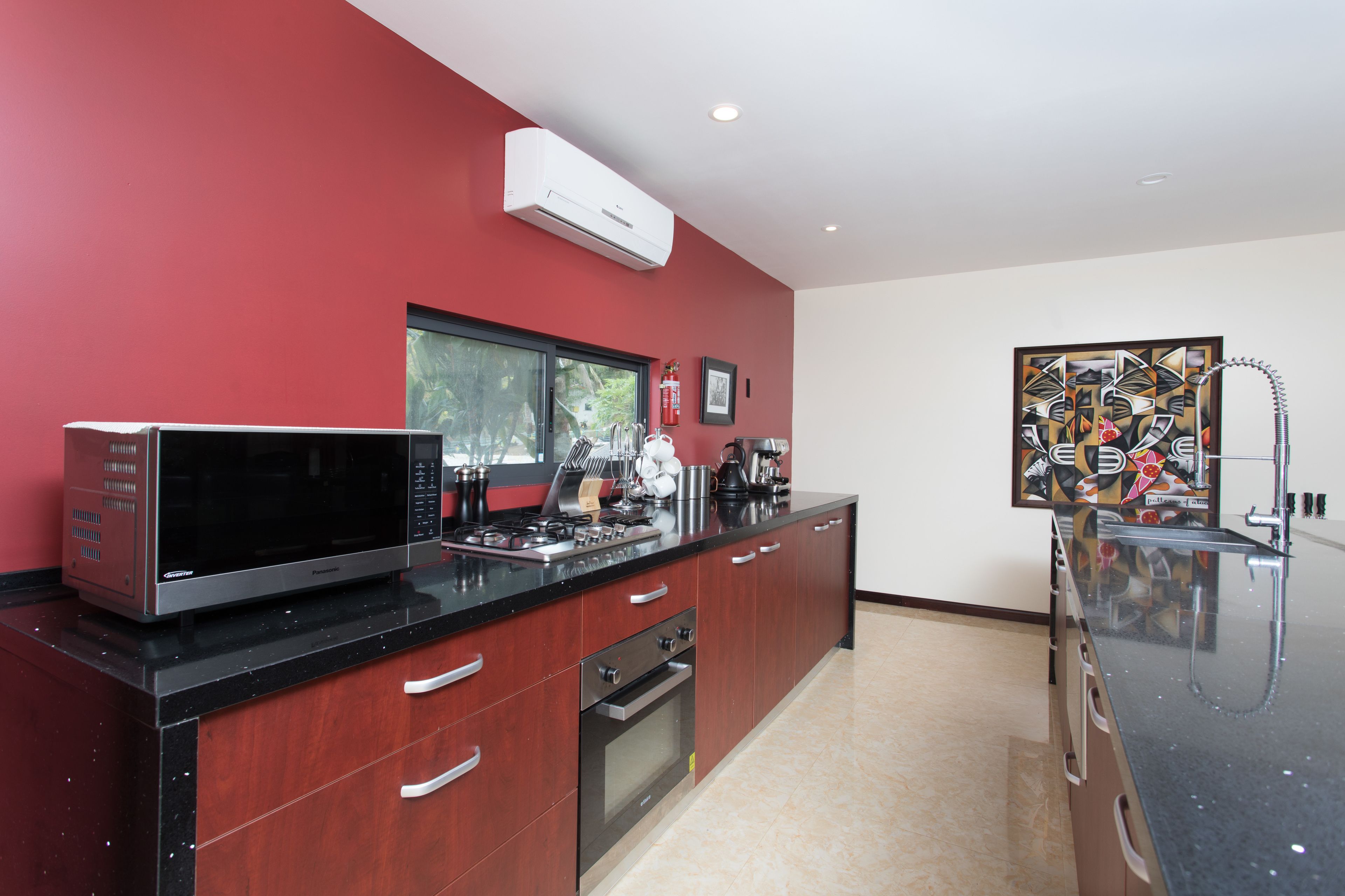 A modern kitchen with a microwave, stove, oven, and a large window.