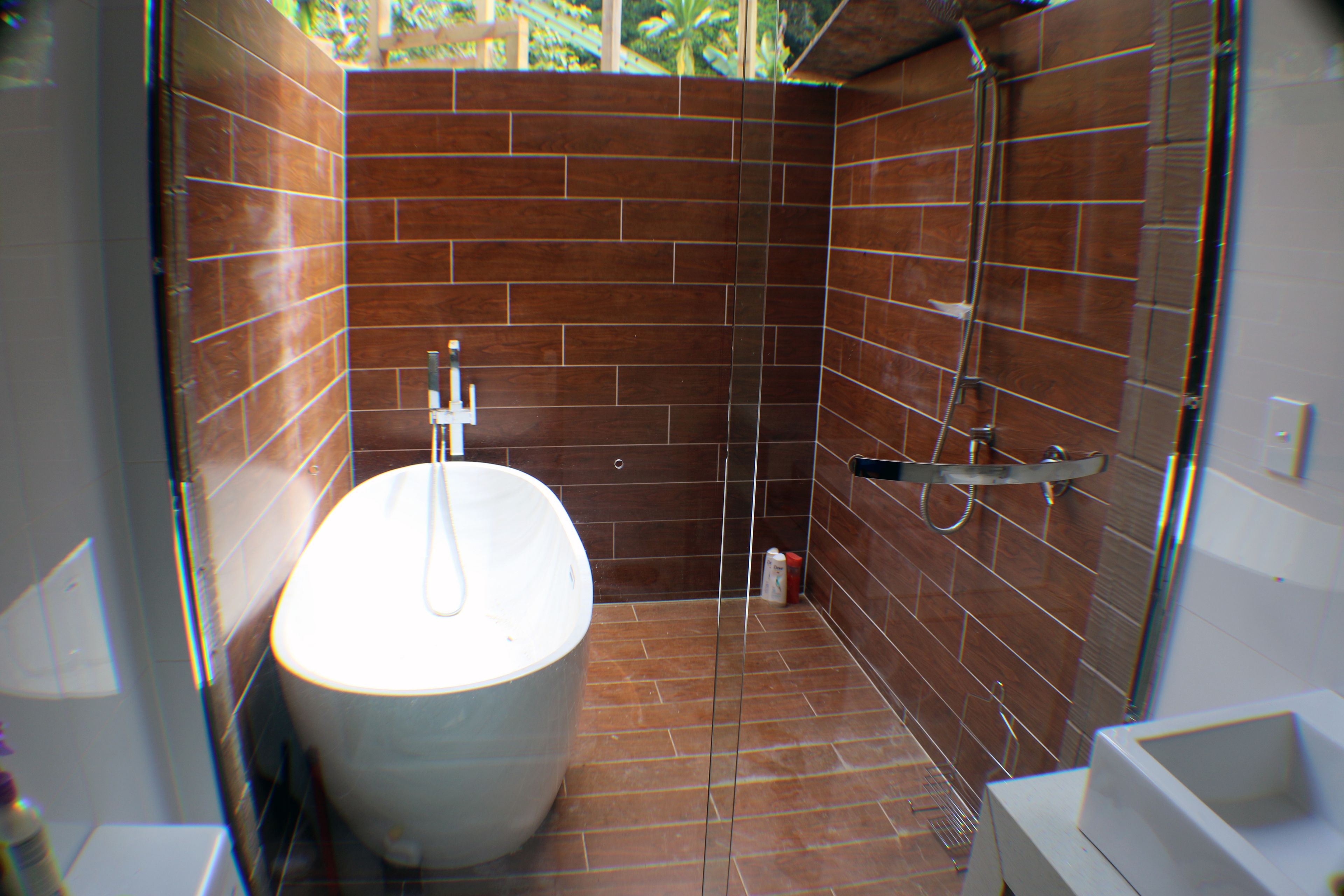 A bathroom with a freestanding bathtub, a shower, and a toilet.