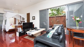 Una sala de estar moderna con televisor, sofá y mesa de comedor.