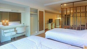 A modern hotel room with two beds, a desk, a chair, a TV, and a sliding door closet. - HuaHin City View (Hua Hin)