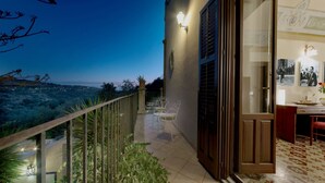 A balcony with a view of the landscape, a door leading to an interior space, and a tiled floor. - Resort Borgo La Fasana formula (RG)