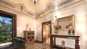 A room with a patterned floor, a fireplace, a mirror, and a chair. - Resort Borgo La Fasana formula (RG)