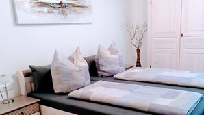 Une chambre à coucher avec un lit, des tables de chevet, une commode, un tapis et un tableau au mur.