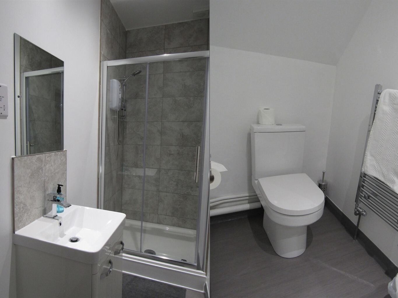 A modern bathroom with a glass shower enclosure, a white sink, and a toilet.