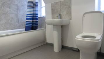 A bathroom with a bathtub, a sink, and a toilet.
