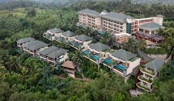Un resort con diversi edifici, ognuno dotato di piscina, immerso in una vegetazione lussureggiante.