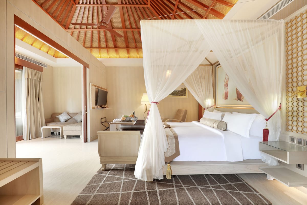 A spacious bedroom with a large bed, a bedside table, a nightstand, and a canopy bed.