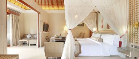 A spacious bedroom with a large bed, a bedside table, a nightstand, and a canopy bed.