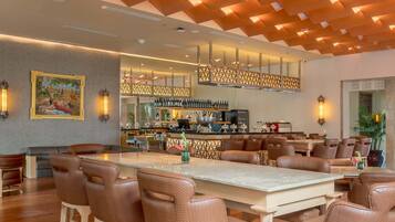 A modern bar area with a wooden ceiling, bar stools, and a bar counter.