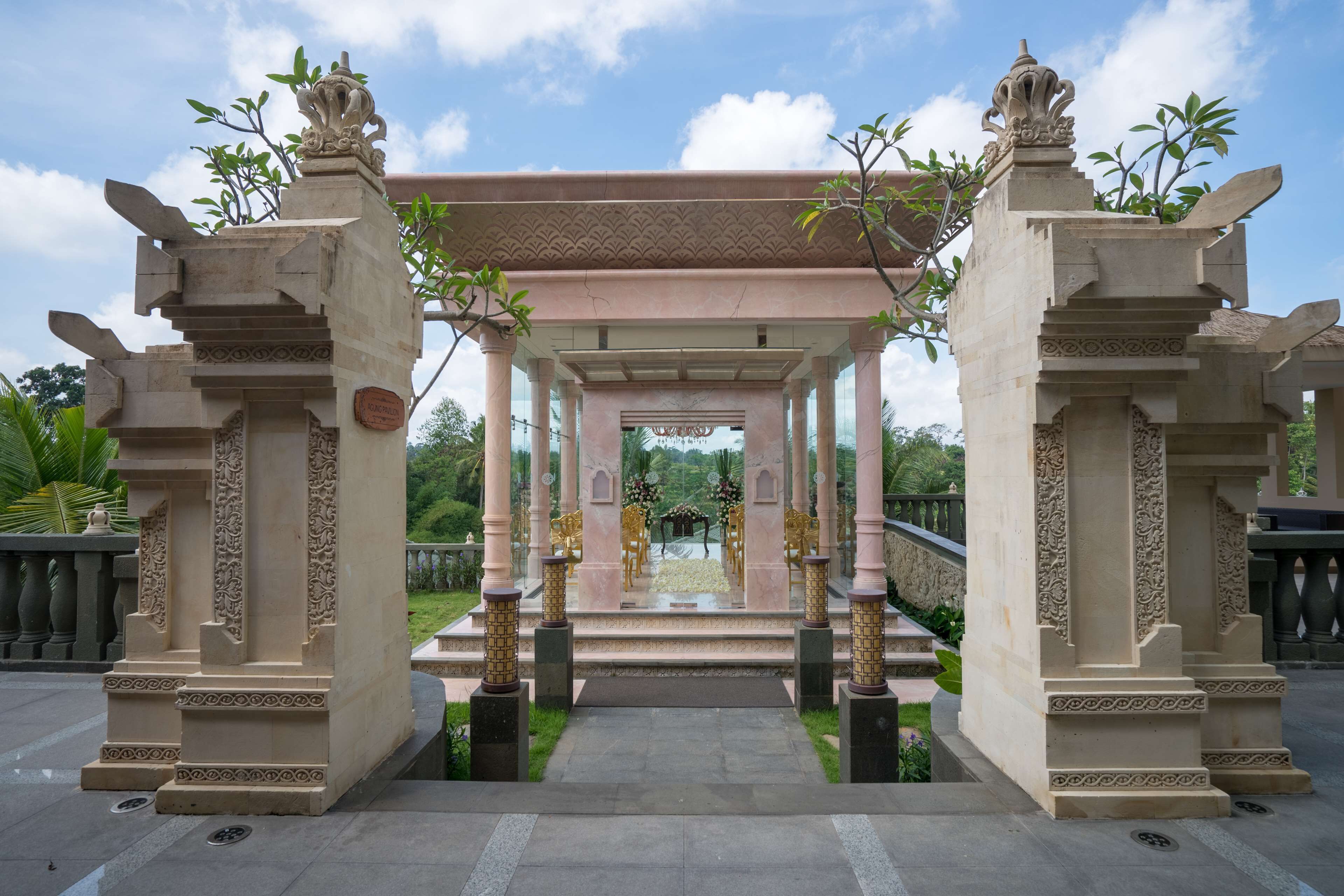 A traditional architectural structure with a central open space, possibly for ceremonies, surrounded by intricately carved columns and a tiled roof.