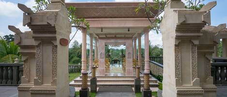 A traditional architectural structure with a central open space, possibly for ceremonies, surrounded by intricately carved columns and a tiled roof.