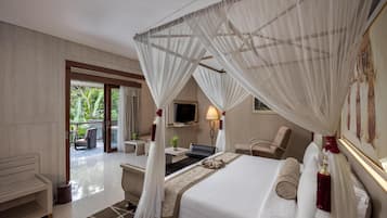 Une chambre d’hôtel équipée d’un lit, d’un bureau, d’une chaise, d’une télévision et d’un balcon avec du mobilier d’extérieur.