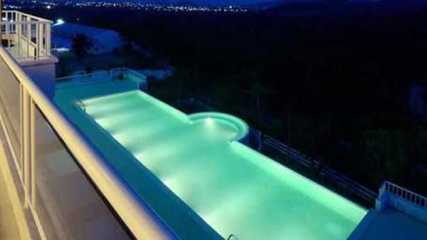 Una piscina con vistas a la ciudad al anochecer.