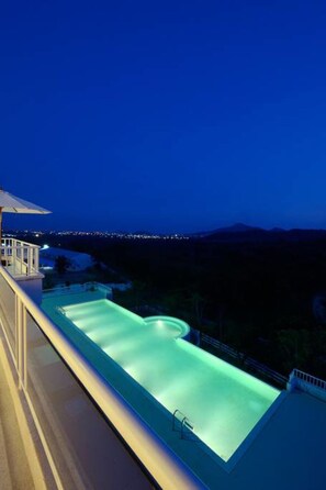 Een buitenzwembad, parasols voor strand/zwembad