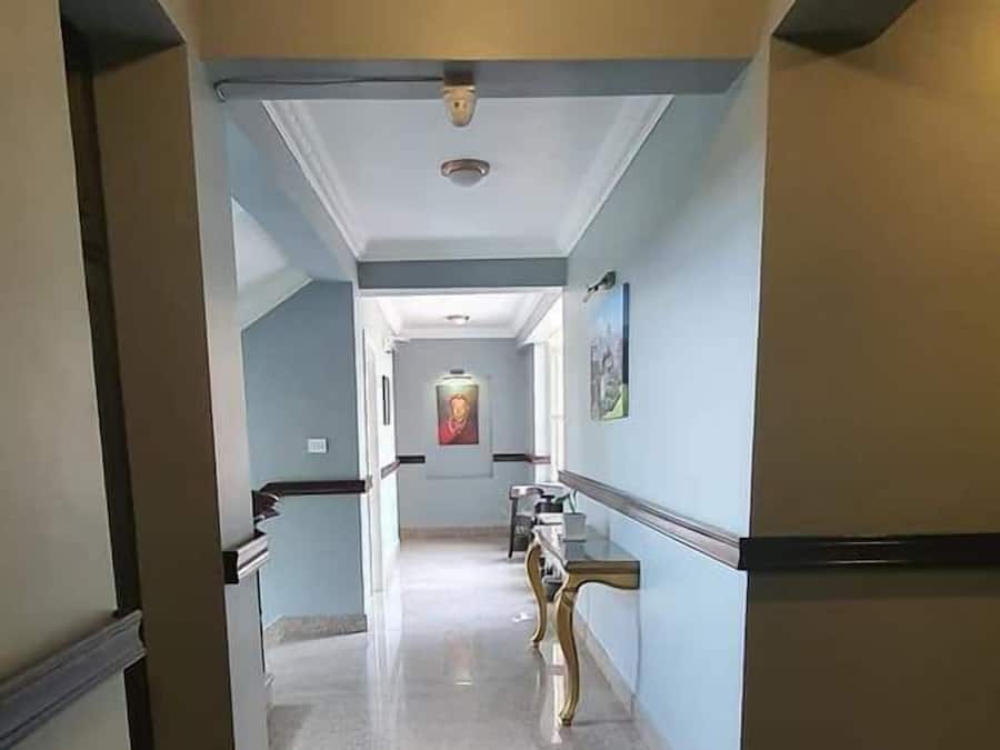 A hallway with a light fixture, a framed picture on the wall, and a door at the end.